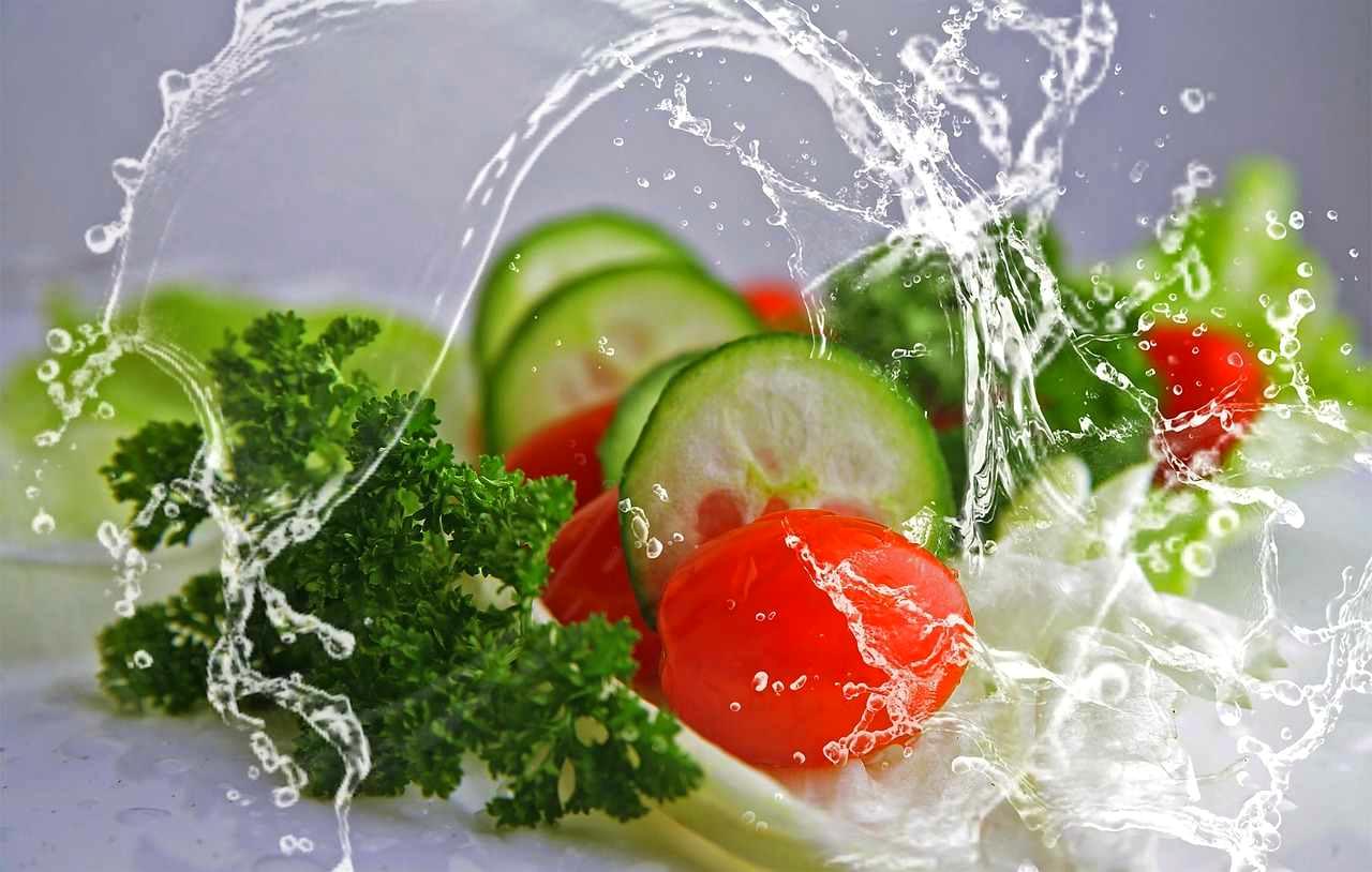 朝の光の中でオクラに根元からたっぷりと水を与える様子